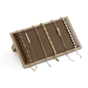 Professional display of rose gold bracelets on a brown stand with elegant metal details