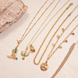 Gold layered necklace set featuring western cowboy charms with turquoise on stone backdrop