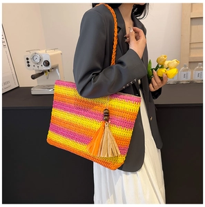 Close-up of colorful rainbow striped straw tote bag with vibrant tassel decoration