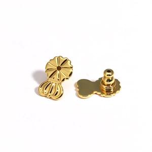 Detail view of gold earring lifters showing front decorative disk and functional back structure