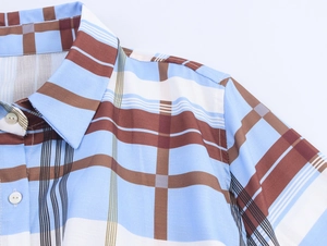 Detailed close-up of a plaid shirt dress collar with blue and brown patterns