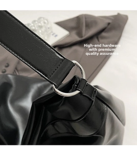 Gros plan du sac fourre-tout en cuir noir brillant avec boucle en métal argenté et détails