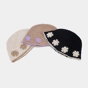 Detail of handcrafted crochet bucket hats featuring floral patterns and wavy hollow edges