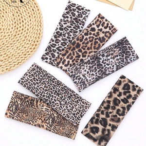 Close-up of leopard and tiger print headbands set on a white minimalist background