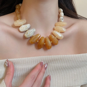 Close-up of multicolored gradient acrylic necklace featuring irregular resin beads on model