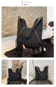 Detail of bohemian black fringe bag with sun embossment and vintage metal rivets