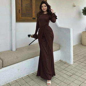Détail du drapé noué à la taille et des poignets évasés d'une robe longue marron