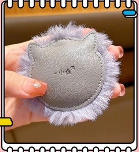 Close-up of cute grey leather and purple plush lion keychain accessory with fine texture