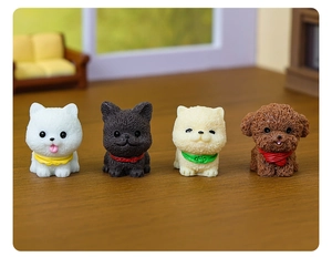 Miniature resin puppy figurines with colorful bibs in a warm home decor setting