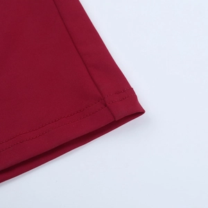 Detalle macro de un vestido rojo vino que muestra la textura de punto y la costura