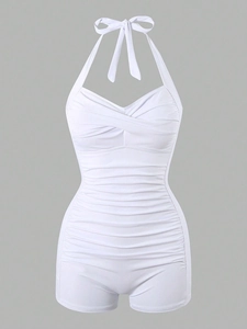 Detail of white halter swimsuit featuring ruched tummy control and boy-leg design
