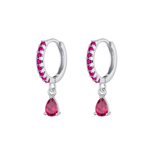 Vue macro de boucles d'oreilles argentées avec zircon rouge poire et petites pierres