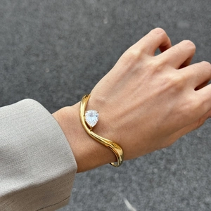 Minimalistischer 18K Goldwellen-Armreif mit einem großen weißen Zirkonia im Birnenschliff