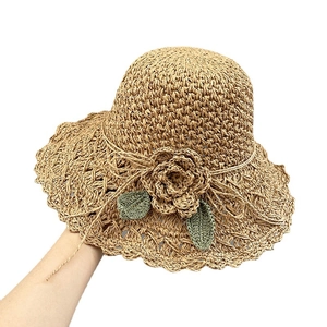 Handmade woven straw sun hat with floral accents and wavy brim for beach vacations