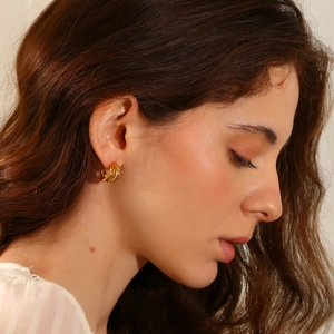 Close-up of 18K gold plated interlocking triple loop earrings worn by a model