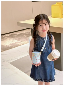 Detail of light blue girls' cherry print bucket bag with metal chain strap and zipper