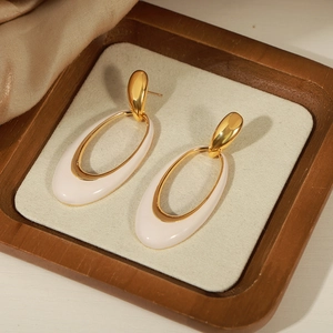 French vintage oval enamel drop earrings in gold and cream on a velvet jewelry box