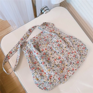 Close-up of floral print cotton tote bag with green accents on clean white background