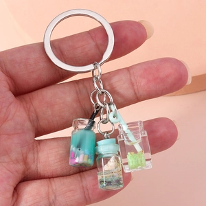 Detailed shot of fruit wish bottle keychain with blue tea cup and mini shell bottle