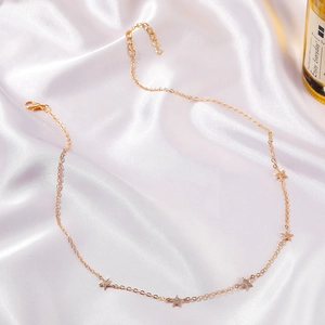 Elegante collana con stelle dorate e cinque pendenti scintillanti su una catena fine