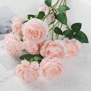 Meraviglioso bouquet di peonie rosa artificiali con foglie verdi per la decorazione domestica.