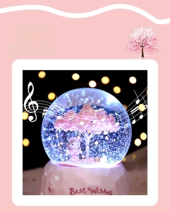 Detail of pink cherry blossom crystal ball music box with Best Wishes engraving on base