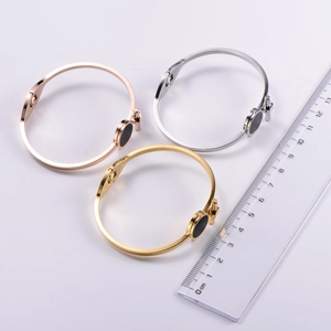 Close-up of three T-bar minimalist bangles in gold, rose gold and silver finishes