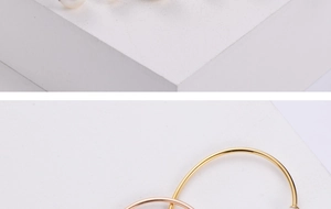 Detail of minimalist gold and rose gold pearl bangle bracelets on white stone blocks