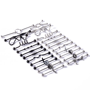 Flat lay of industrial barbells in stainless steel with cross, heart, and snake designs