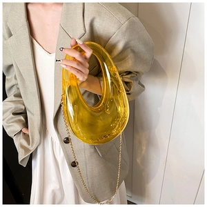 Fashionable yellow acrylic ring bag styled with beige blazer and metal chain strap