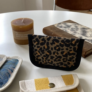 Detail of durable canvas coin purses with leopard print, stripes, and metal button snaps