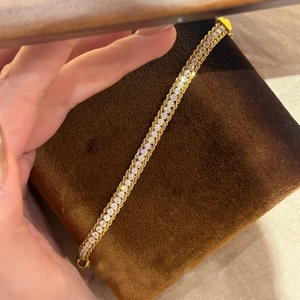 Détail d'un bracelet chaîne vintage en or avec accents géométriques en diamant sur velours