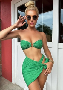Detail of green polka dot bikini top with golden ring and textured ribbed fabric