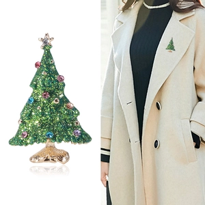 Detail view and model wearing a green enamel Christmas tree brooch with colorful gems