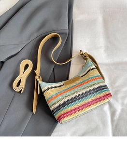 Close-up of colorful striped woven shoulder bag with additional leather strap and texture