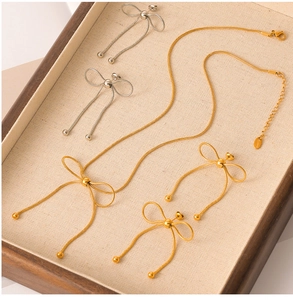 Detailed view of butterfly bow jewelry set with gold necklace and mixed metal earrings