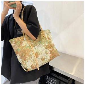Detail of vintage floral jacquard tote bag with textured fabric and leather shoulder strap