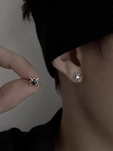Detailed close-up of octagram star earrings with black and white zircon inlay on ear