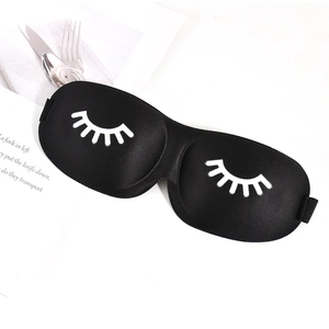 Detail of 3D contoured sleep mask in black with white eyelash print and elastic strap