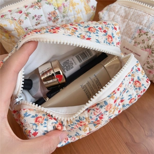 Detailed view of spacious floral quilted cotton pouch holding various skincare items