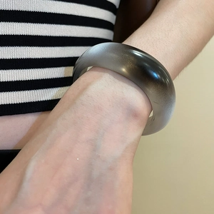 Detail shot of a minimalist grey and black gradient acrylic resin geometric bangle bracelet
