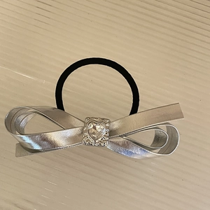 Dettaglio di elastico per capelli con fiocco argento e strass a cuore per capelli donna