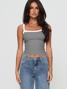 Close-up of grey lace trim camisole paired with blue denim jeans in a studio shot