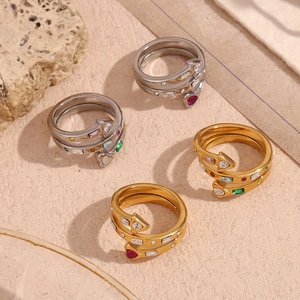 Macro detail of 18K gold and silver rings with colorful heart and arrow zircons