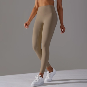 Detail shot of high-waisted tan yoga pants showing seamless fabric and sculpting fit
