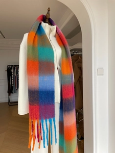 Macro shot of thick rainbow plaid scarf featuring soft mohair texture and chunky tassels