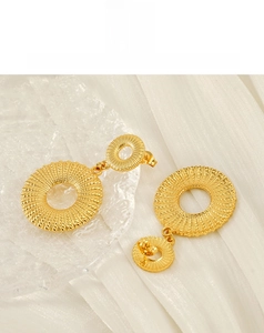 Close-up of 18K gold-plated stainless steel hoop earrings with radial texture detail