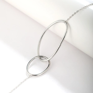 Close-up of minimalist interlocking double circles on a silver stainless steel chain