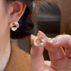 14K gold plated Mobius twisted flower stud earrings with pearl bead edge on model