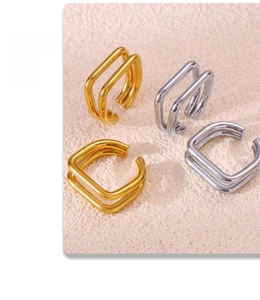Detail of square U-shaped open rings in gold and silver finish on textured stone